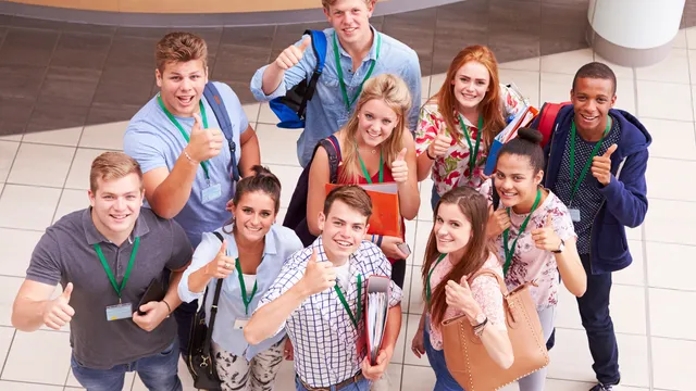 Group of students traveling together, smiling and giving thumbs up, representing student group travel experiences.
